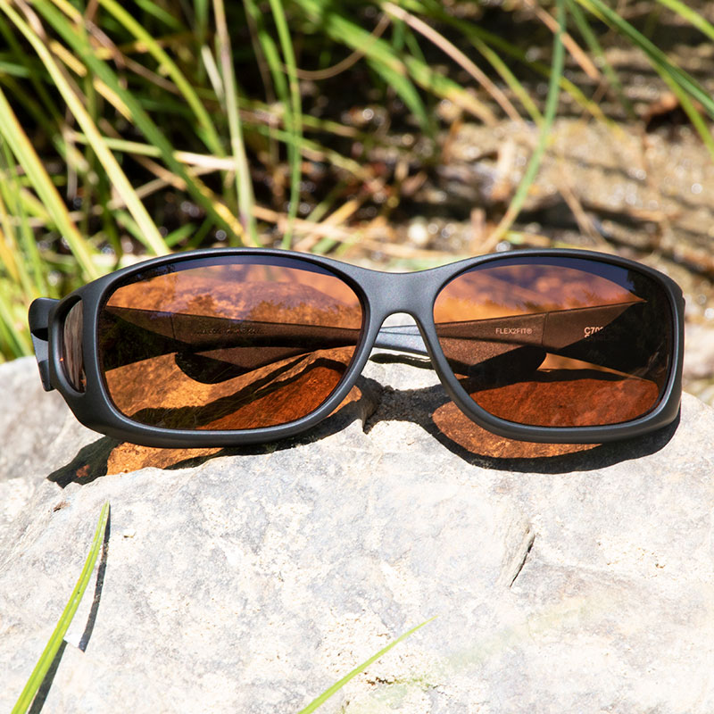 Cocoons Style Line MX Black Frame with Polarized Copper Lenses resting outdoors